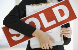 Woman holding Sold Sign